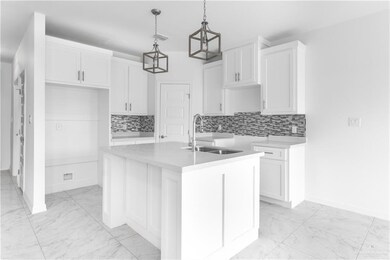Kitchen featuring an island with sink, sink, decorative light fixtures, and tasteful backsplash