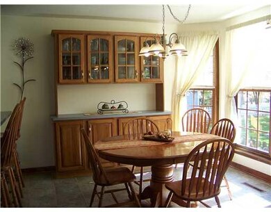 Dining Room. Kitchen/Dining area features an oak buffet/server, glass doors on upper cabinets and a triple window bump out for lots of natural light.
