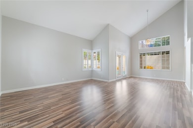 Unfurnished living room featuring high vaulted cei