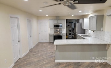 Kitchen featuring light countertops, a peninsula, appliances with stainless steel finishes, decorative backsplash, and recessed lighting
