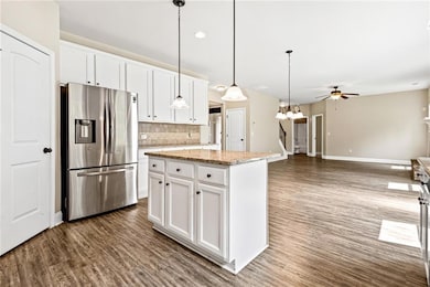 Kitchen featuring stainless steel fridge, backsplash, ceiling fan, and dark wood finished floors