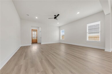 Unfurnished living room featuring a ceiling fan, l