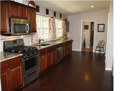 Kitchen has granite countertops and stylish tile b