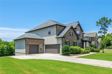 View of front of house featuring a front lawn, concrete driveway, an attached garage, a shingled roof, and brick siding