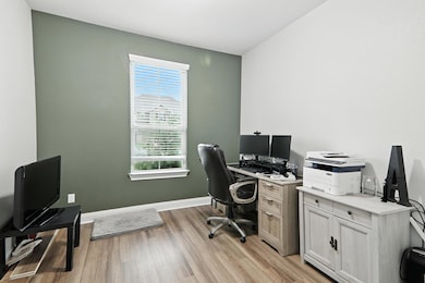 Home office with light wood-type flooring and bas