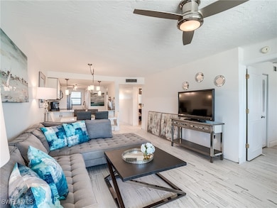Living room featuring ceiling fan, a textured ceil