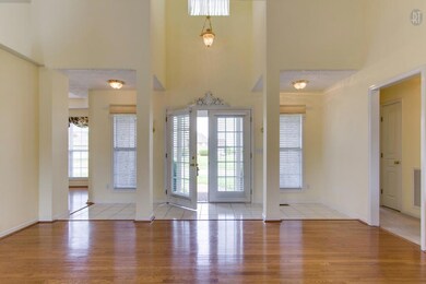 FRENCH DOORS OPENS INTO THE LIVING ROOM HAS TILE FOYER AND TALL WHITE COLUMNS WITH DINING ROOM TO THE RIGHT