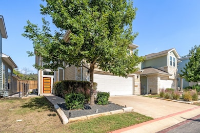View of front of property featuring stone siding, concrete driveway, and an attached garage