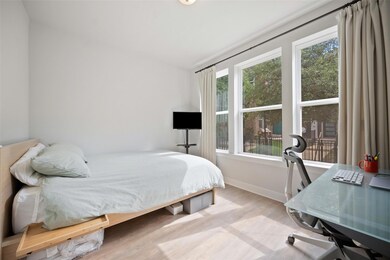 Bedroom with multiple windows, wood finished floo