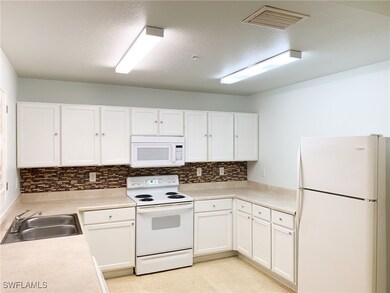 Kitchen featuring white appliances, decorative bac