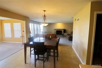 Dining space with a fireplace, light floors, and light colored carpet