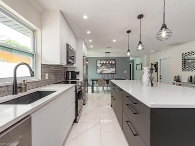 Kitchen featuring hanging light fixtures, white ca