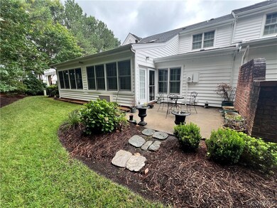 Rear view of property featuring a lawn and a patio
