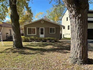 View of front of property featuring a front lawn and brick siding