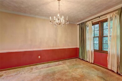 Empty room with ornamental molding, a chandelier, a textured ceiling, and carpet flooring