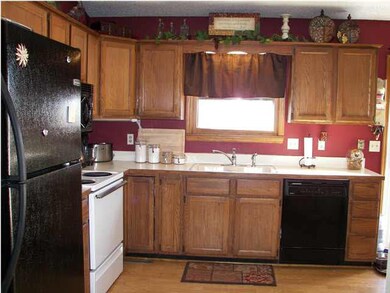 The kitchen is open and has wood laminate flooring