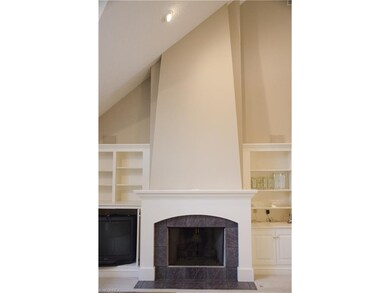 Gas fireplace is flanked by built in shelves and e