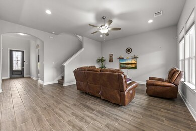 Living area with arched walkways, baseboards, vis