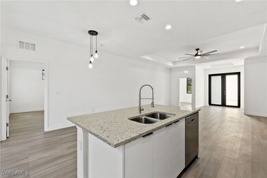 Kitchen featuring pendant lighting, sink, white ca