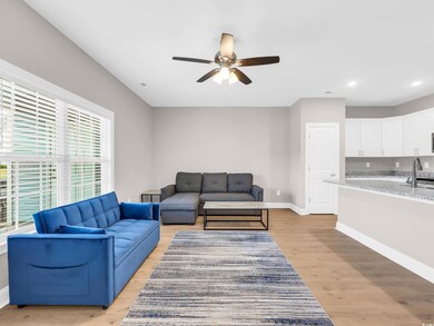 Living area featuring light wood finished floors, ceiling fan, and recessed lighting