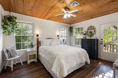 Bedroom featuring wooden ceiling, dark wood finished floors, access to exterior, a ceiling fan, and ornamental molding