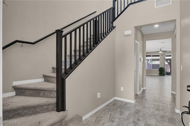 Stairway with ceiling fan and baseboards