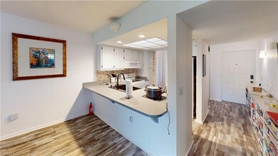 Kitchen featuring white cabinetry, sink, white app