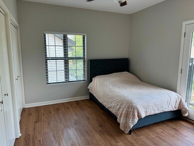 Bedroom with wood finished floors and multiple wi