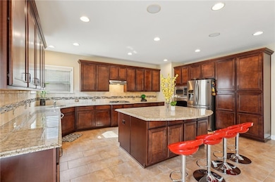 Kitchen with under cabinet range hood, light stone