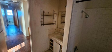 Bathroom with tiled shower, vanity, and hardwood /