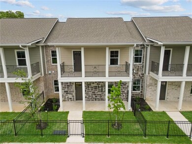 Rear view of property featuring stone siding, a ga