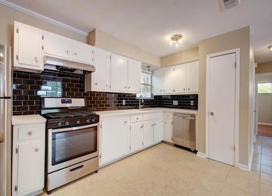 Kitchen with under cabinet range hood, white cabi