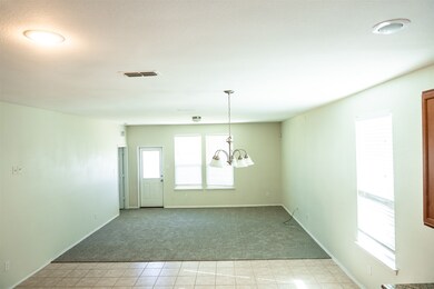 Living room featuring light carpet, light tile patterned floors, and a chandelier
