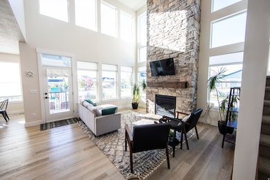 Living area with light wood finished floors, a fireplace, plenty of natural light, and a high ceiling