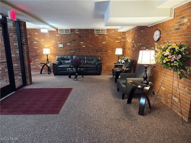 Lobby area featuring carpet and brick wall