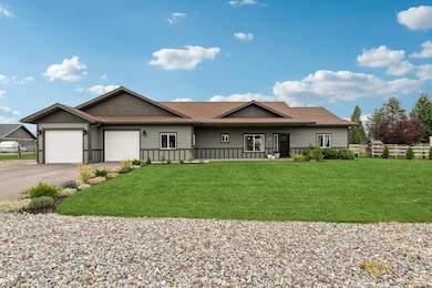 Ranch-style home with roof with shingles, driveway, and a garage