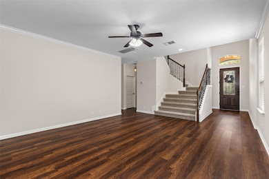 Unfurnished living room with crown molding, stair