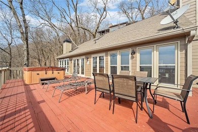 Deck with outdoor dining area and a hot tub