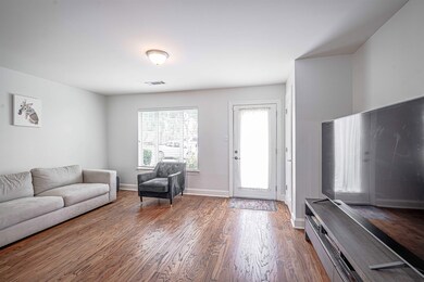 Living area with dark wood-style flooring and baseboards