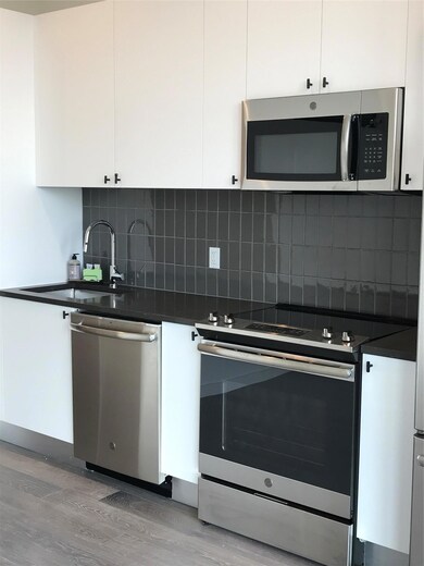 Kitchen with dishwasher, range, dark countertops,