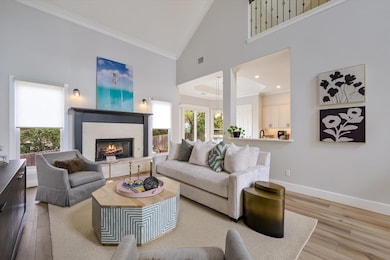 Living area with crown molding, wood finished flo