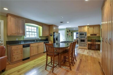The kitchen features Dacor satinless steel appliances, granite, hickory hardwood floors, convection oven, warming drawer, breakfast bar, custom maple cabinetry, refrigerator, pantry, microwave, dishwasher, trash compactor, and food disposal.