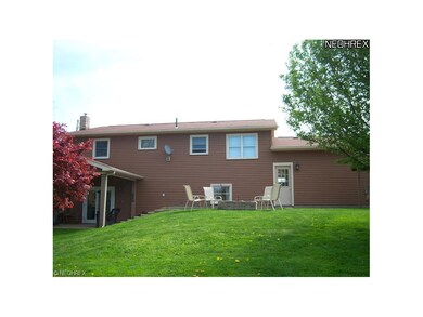rear view of attached garage and higher patio