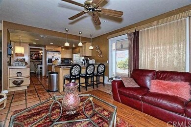 Family room with ceiling fan and view of breakfast