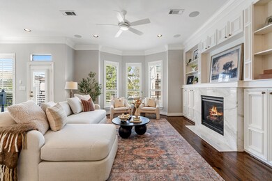 The spacious living room is a haven for relaxation, featuring a marble fireplace nestled in custom cabinets.