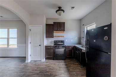 Kitchen with backsplash, black appliances, light s