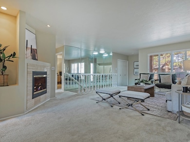 Carpeted living area with a tiled fireplace and recessed lighting