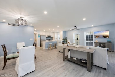 Living room with recessed lighting, light wood-style flooring, ceiling fan, and a chandelier
