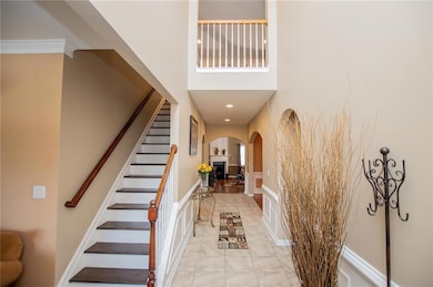 Entrance foyer with arched walkways, stairs, marble finish floors, a towering ceiling, and recessed lighting