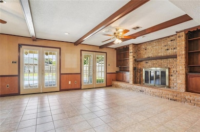 LARGE DEN WITH BRICK FIREPLACE AND DBL DOORS TO PATIO